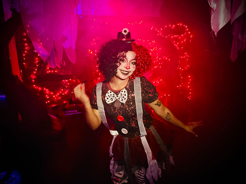 Clown monster standing afront red lights.